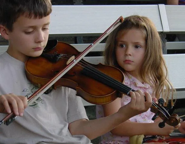 Young Mitch Metz holding a violin during a childhood performance
